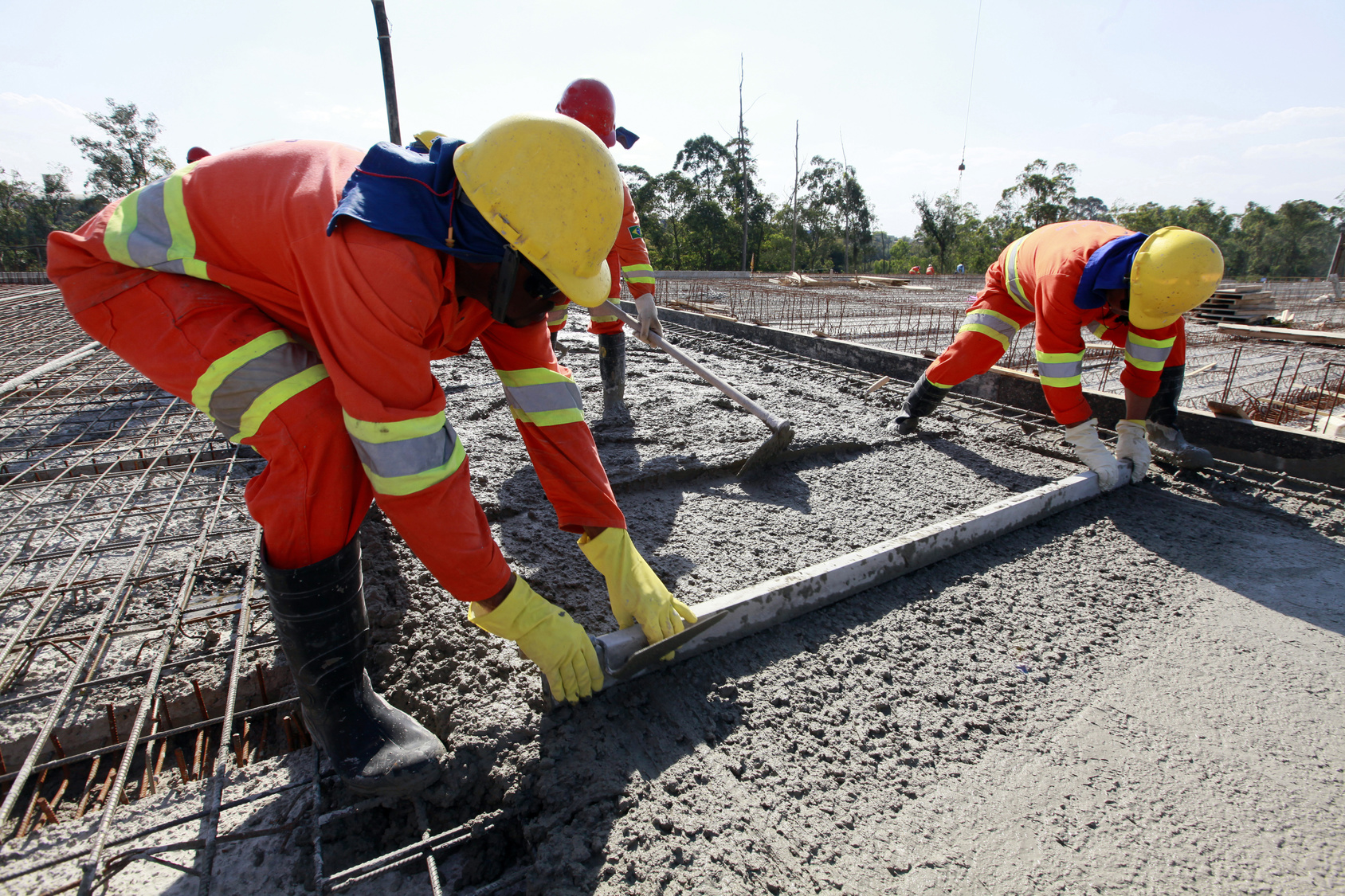 workers pouring cement in road construction on brazil