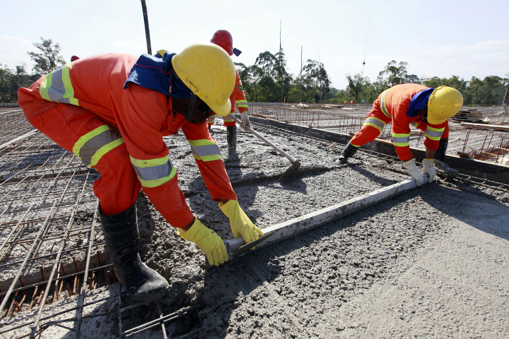 workers pouring cement in road construction on brazil
