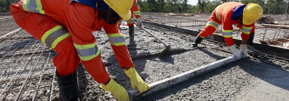 workers pouring cement in road construction on brazil